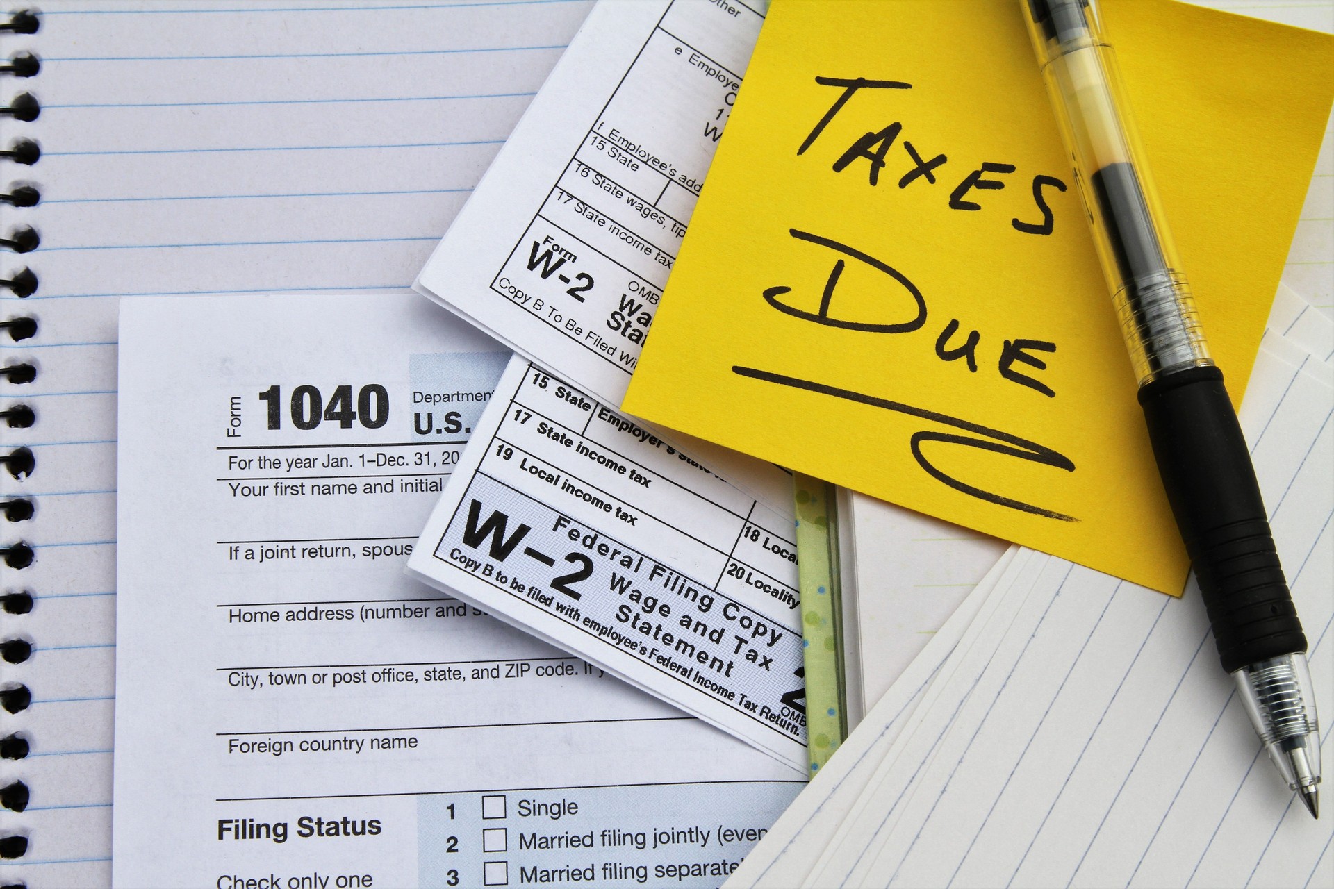 Tax return forms and wage statements with note Taxes Due.